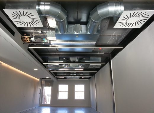 Interior view of a modern space with exposed ductwork and ventilation fans on the ceiling