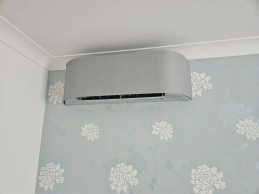 Light grey Toshiba Haroi air conditioning unit mounted on a light blue wall with floral patterns.