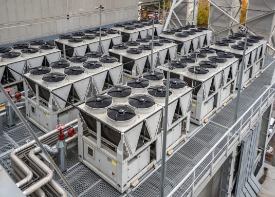 Roof-mounted industrial chiller units arranged in rows.