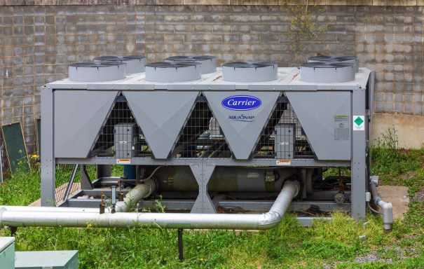 Picture of a single carrier chiller located outside of a building at ground level